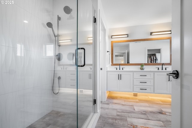 bathroom featuring vanity and a shower with door