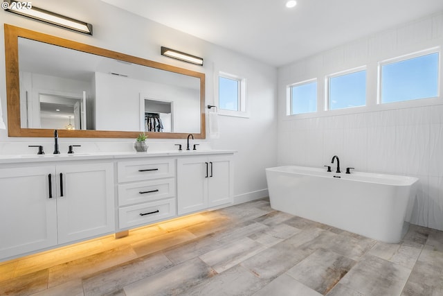 bathroom featuring hardwood / wood-style flooring, vanity, and a washtub