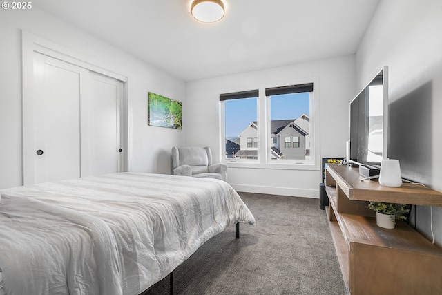 bedroom with dark colored carpet and a closet