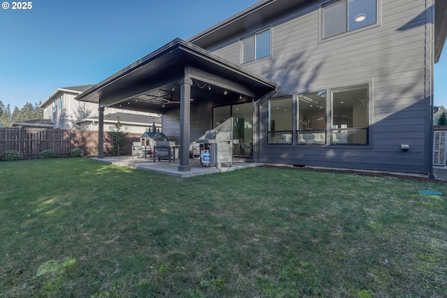 rear view of property with ceiling fan, a yard, and a patio