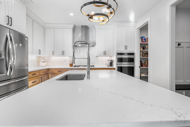 kitchen featuring appliances with stainless steel finishes, pendant lighting, white cabinets, and light stone counters