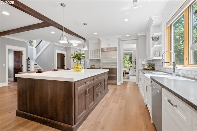 4015 NE 38th Ave, Portland, OR 97212 - kitchen featuring stainless steel appliances, ornamental molding, white cabinetry, dark brown cabinets, and plenty of natural light