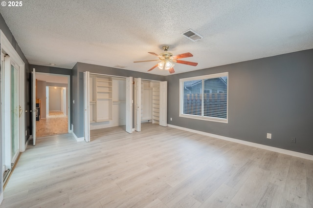 446 44th Ave, Salem, OR 97317 - unfurnished bedroom featuring a textured ceiling, multiple closets, light wood-style floors, baseboards, and a ceiling fan