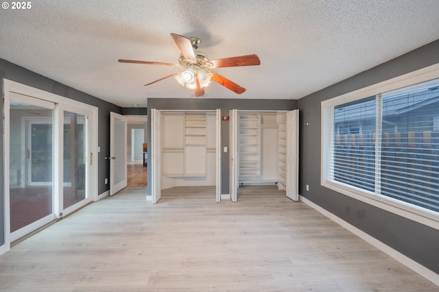 446 44th Ave, Salem, OR 97317 - unfurnished bedroom with a textured ceiling, access to outside, light wood-style flooring, baseboards, and multiple closets