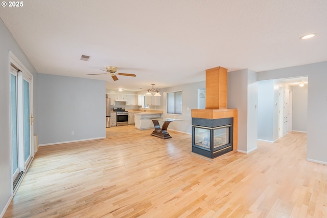 446 44th Ave, Salem, OR 97317 - unfurnished living room with light wood finished floors, baseboards, ceiling fan, and recessed lighting