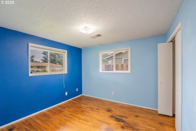 446 44th Ave, Salem, OR 97317 - unfurnished bedroom featuring wood finished floors, a textured ceiling, and baseboards