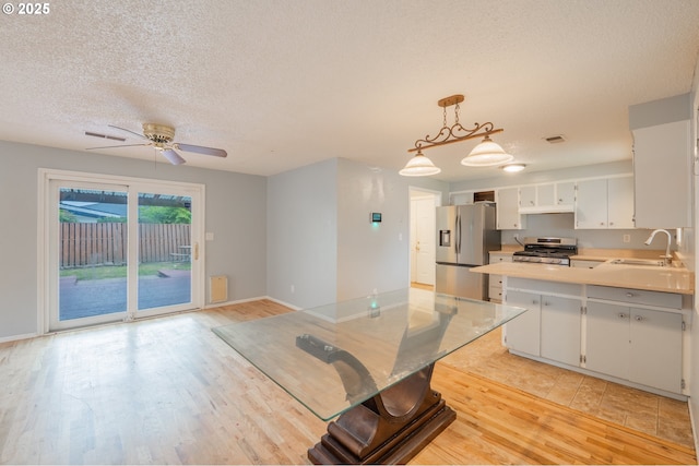 446 44th Ave, Salem, OR 97317 - kitchen with stainless steel appliances, a sink, a textured ceiling, light wood finished floors, and light countertops