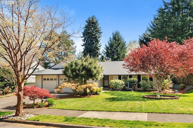 ranch-style house featuring an attached garage, a front lawn, and driveway