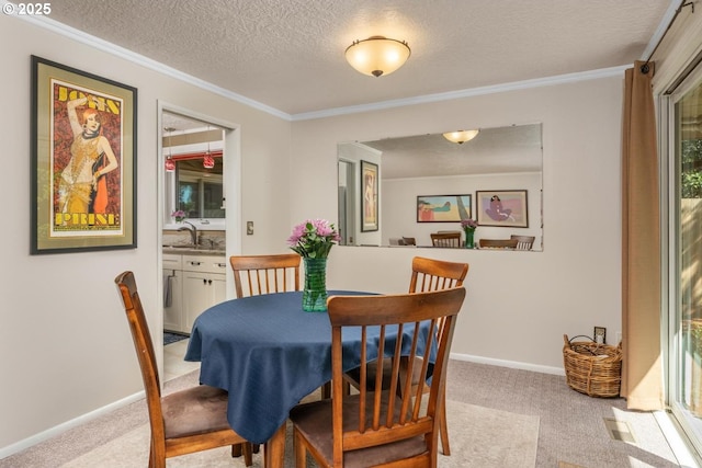 dining area featuring baseboards, ornamental molding, a textured ceiling, and light carpet