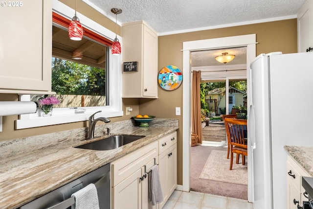 kitchen featuring freestanding refrigerator, a sink, light tile patterned flooring, and a healthy amount of sunlight