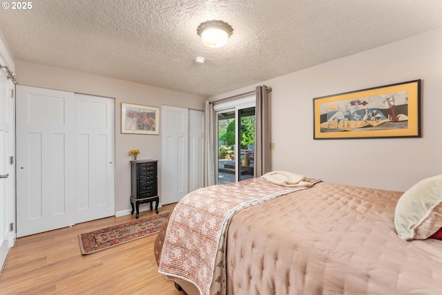 bedroom featuring light wood-style floors, a textured ceiling, and access to exterior