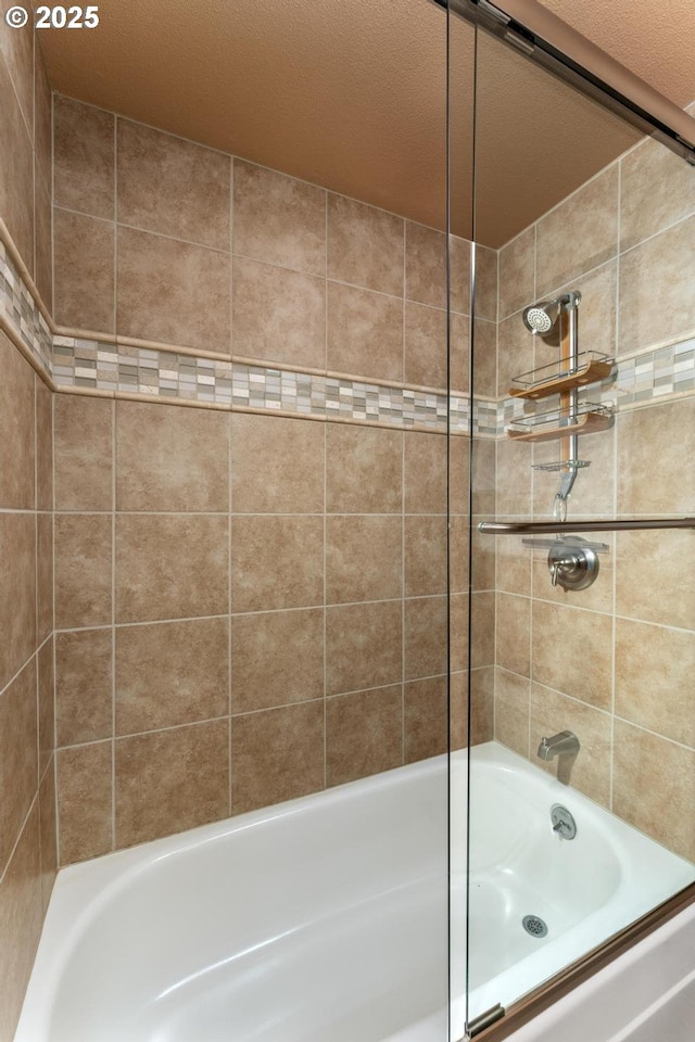 bathroom with combined bath / shower with glass door
