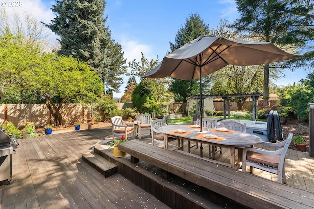 deck with a fenced backyard, a hot tub, and outdoor dining space