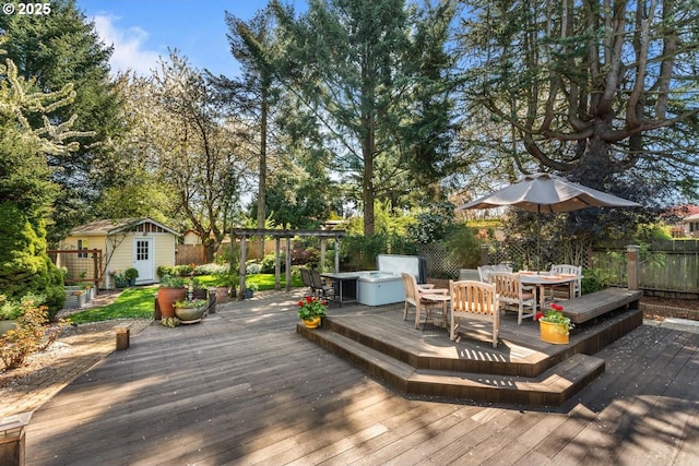 deck with fence, an outbuilding, outdoor dining area, and a shed