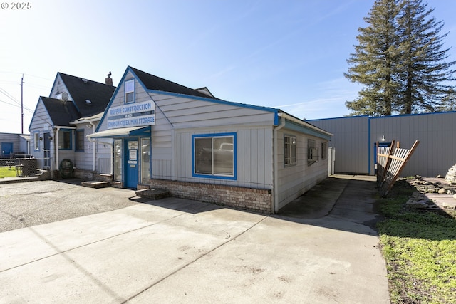 view of front facade featuring board and batten siding and fence