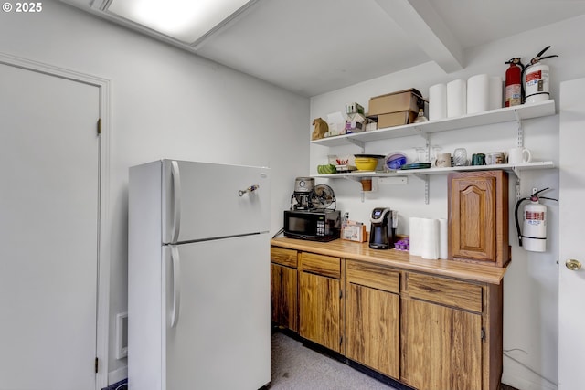 8935 SE Stanley Pl, Portland, OR 97206 - kitchen with freestanding refrigerator, open shelves, brown cabinets, and black microwave