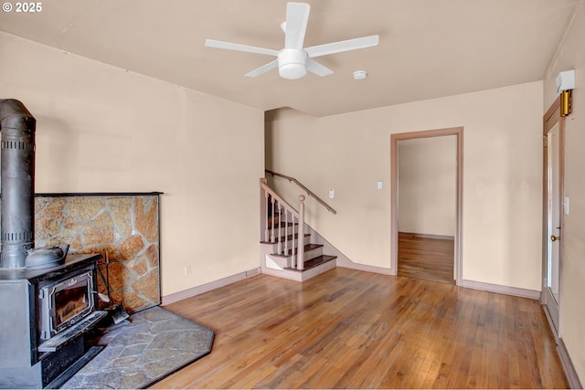 8935 SE Stanley Pl, Portland, OR 97206 - living area with stairway, ceiling fan, a wood stove, and hardwood / wood-style flooring