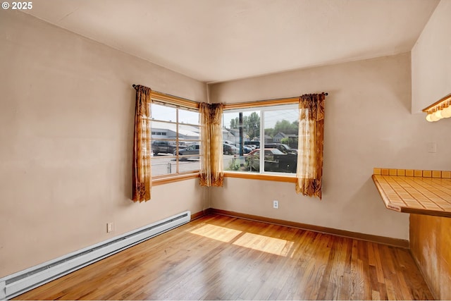 8935 SE Stanley Pl, Portland, OR 97206 - empty room with baseboards, baseboard heating, and hardwood / wood-style flooring
