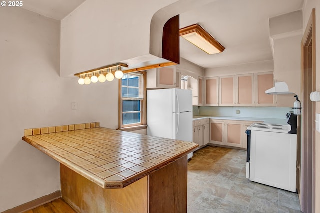 8935 SE Stanley Pl, Portland, OR 97206 - kitchen with tile counters, a peninsula, range hood, and white appliances