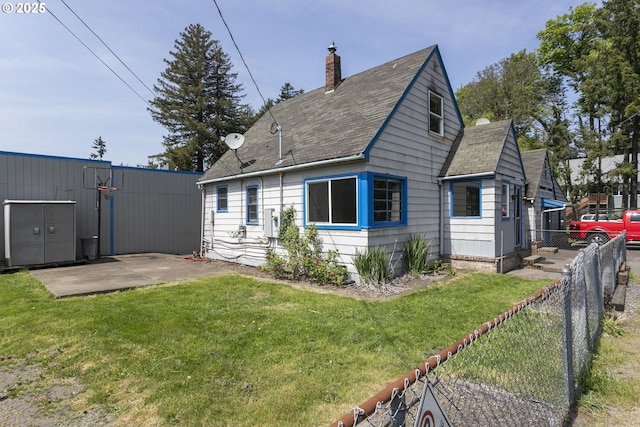 8935 SE Stanley Pl, Portland, OR 97206 - back of house with a yard, fence, a chimney, and roof with shingles