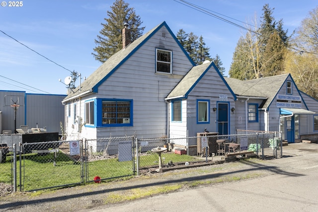 view of front of property with a fenced front yard, a front yard, and a gate