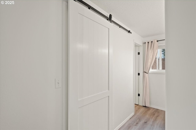 15314 NE 88th St, Vancouver, WA 98682 - hallway with light wood-style floors, a barn door, and a textured ceiling