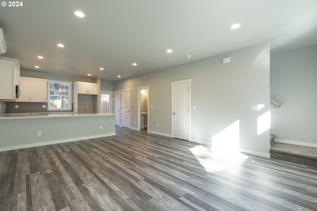 unfurnished living room with sink and hardwood / wood-style flooring