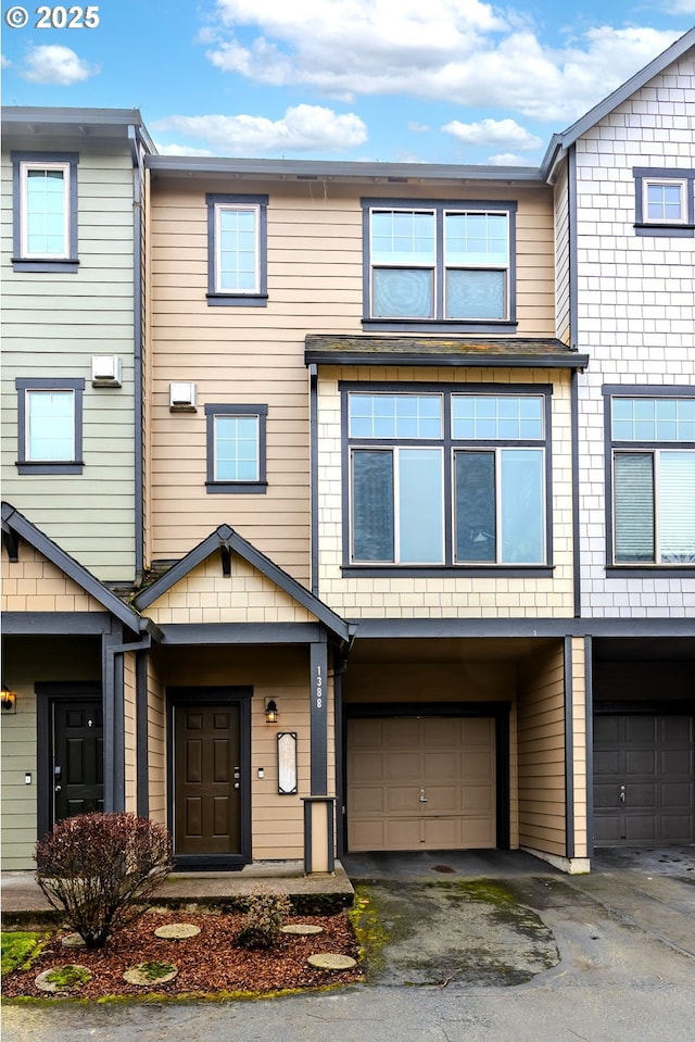 multi unit property featuring an attached garage and driveway