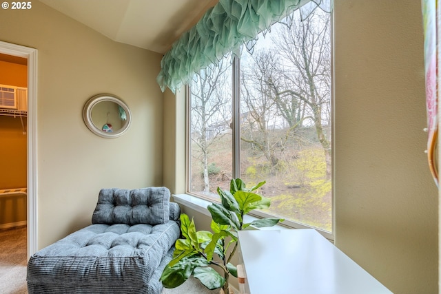 living area featuring carpet floors, a wall mounted AC, and lofted ceiling