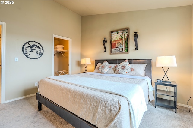 bedroom with carpet floors, a spacious closet, baseboards, and vaulted ceiling