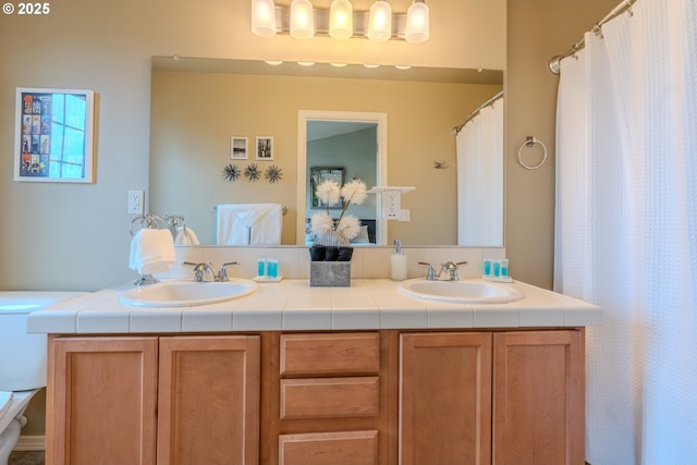 full bathroom featuring toilet, double vanity, and a sink