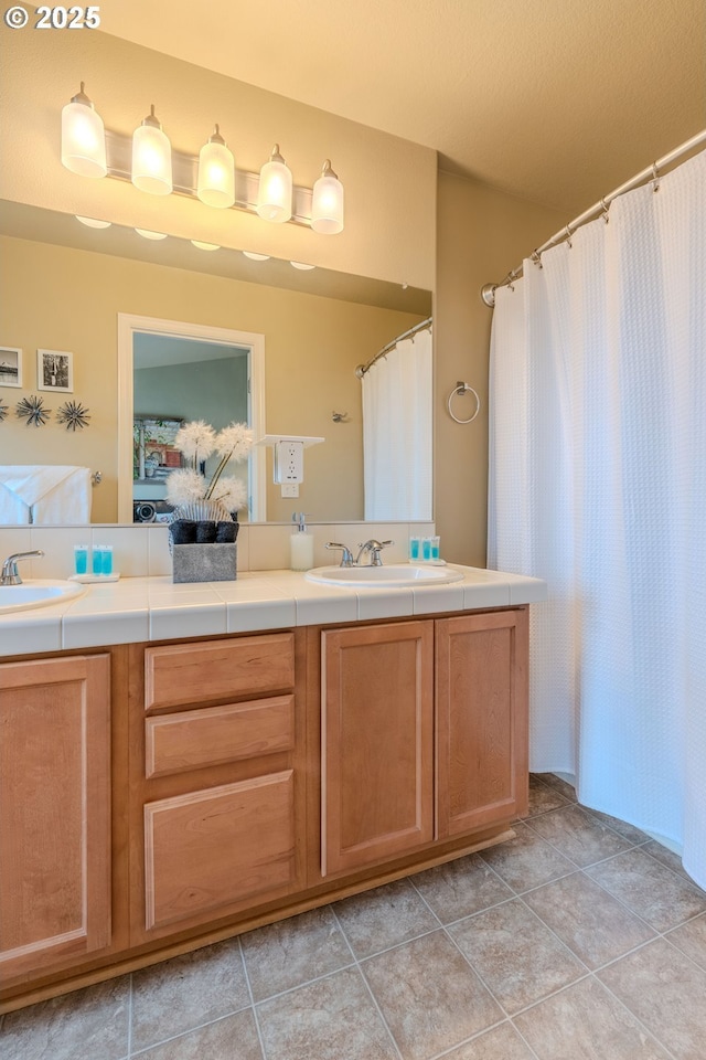 bathroom featuring double vanity, tile patterned flooring, and a sink