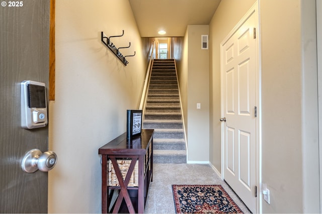 stairway featuring carpet floors, visible vents, and baseboards