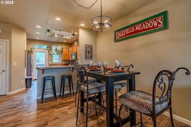 dining room with recessed lighting, baseboards, and wood finished floors