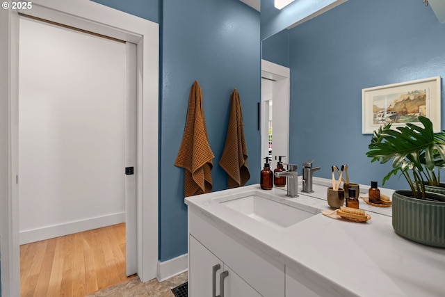 bathroom with baseboards, vanity, and wood finished floors