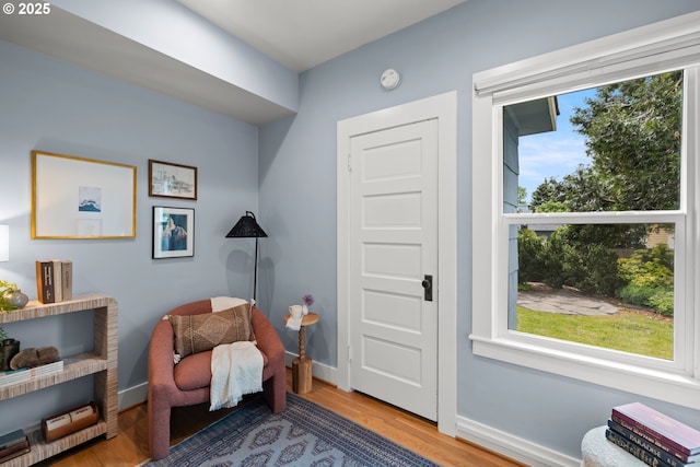 living area with plenty of natural light, wood finished floors, and baseboards
