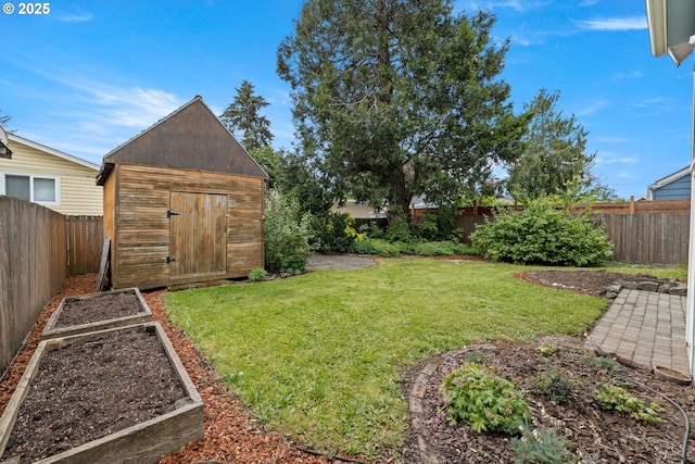view of yard featuring a storage shed, an outbuilding, and a vegetable garden