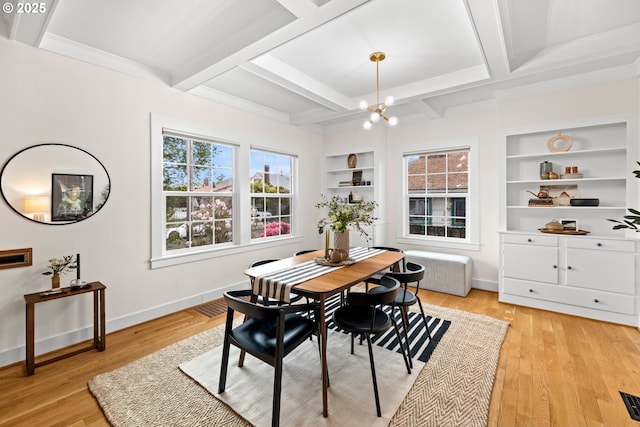 dining area with built in shelves, a chandelier, light wood-style flooring, baseboards, and beamed ceiling