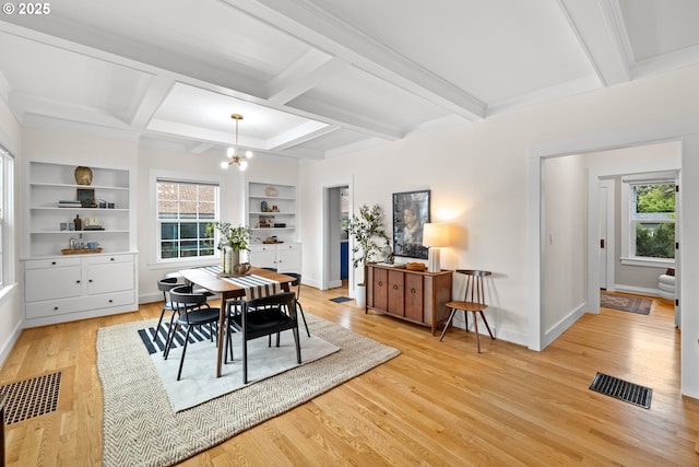 dining space featuring healthy amount of natural light, a chandelier, coffered ceiling, light wood-style floors, and baseboards