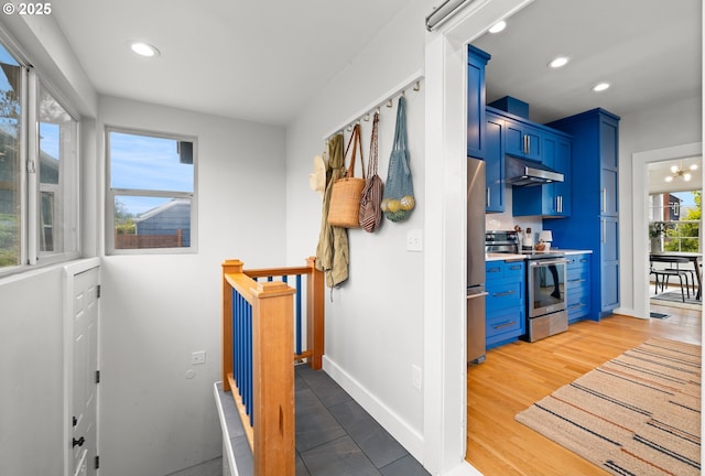hall with recessed lighting, baseboards, and an upstairs landing