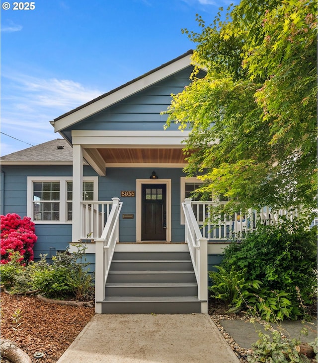 view of front of home featuring covered porch and a shingled roof