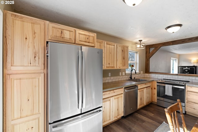 kitchen featuring a textured ceiling, stainless steel appliances, dark wood-type flooring, a sink, and light brown cabinetry