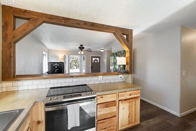 kitchen with baseboards, dark wood-style flooring, stainless steel range with electric cooktop, light brown cabinets, and wooden counters