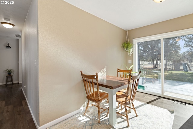 dining space featuring visible vents, baseboards, and wood finished floors