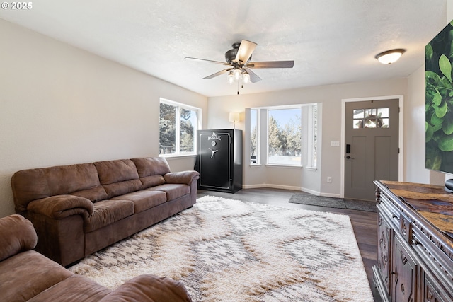 living room featuring a textured ceiling, dark wood-type flooring, and a wealth of natural light