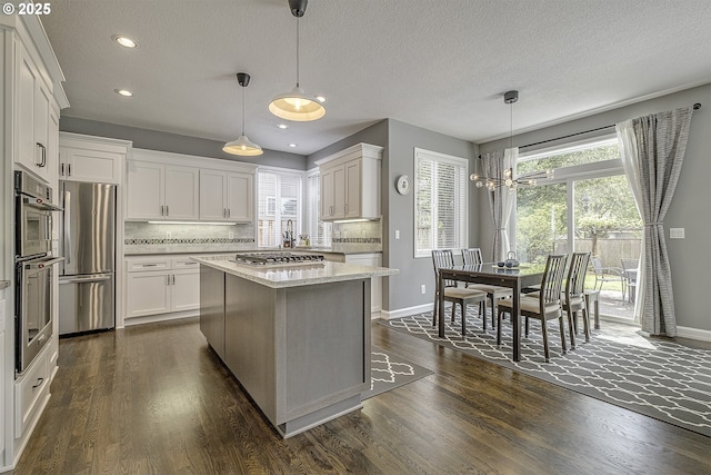 15178 NW Channa Dr, Portland, OR 97229 - kitchen featuring appliances with stainless steel finishes, baseboards, white cabinetry, dark wood-type flooring, and recessed lighting