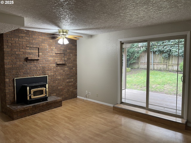 unfurnished living room with a textured ceiling, wood finished floors, and a healthy amount of sunlight