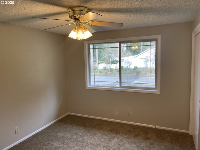 carpeted empty room featuring a textured ceiling, ceiling fan, plenty of natural light, and baseboards