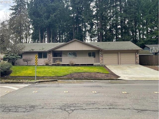 single story home featuring a garage, covered porch, concrete driveway, stone siding, and a front lawn