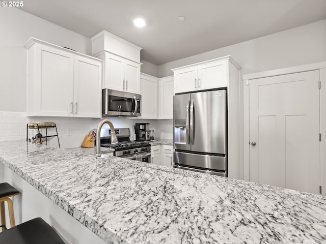2421 S Trail View Ct, Ridgefield, WA 98642 - kitchen with backsplash, light stone countertops, white cabinets, stainless steel appliances, and recessed lighting